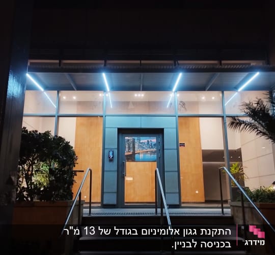 סוכך מתכת עם תאורה מעל כניסה לבניין